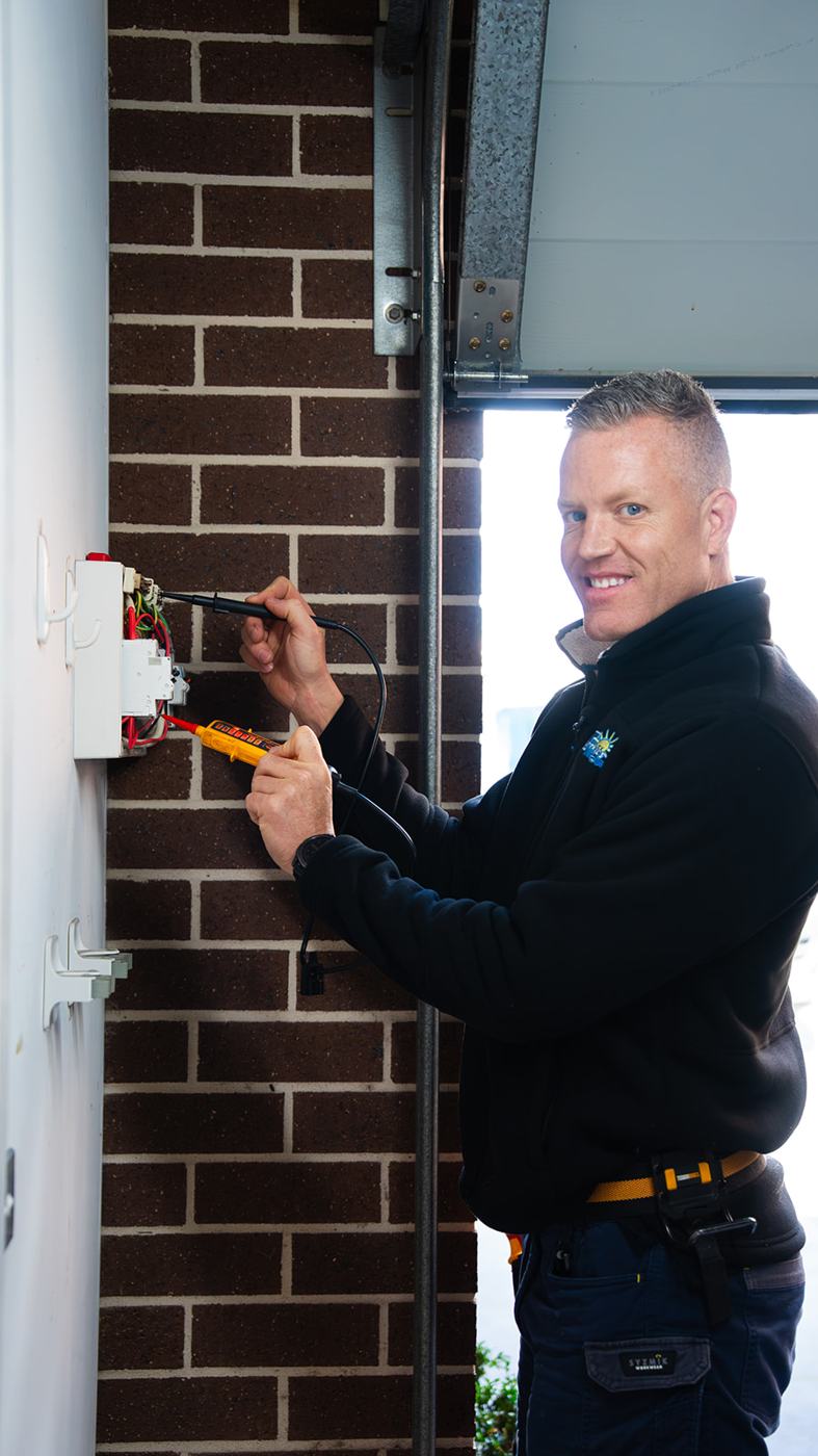 Electrician smiling while working at an external switchboard