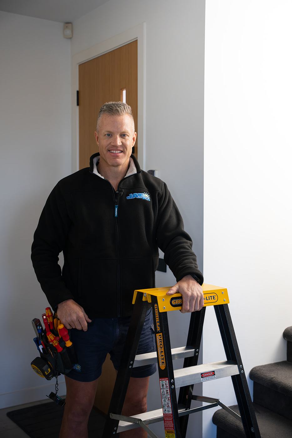 Lance from JAT Electrics standing with a step ladder