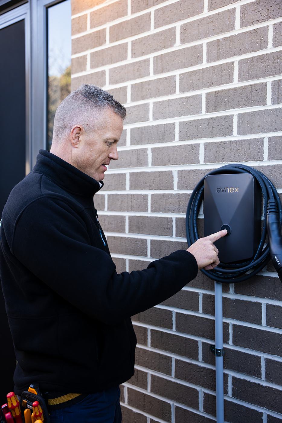 Lance from JAT Electrics beside an installed EV charger