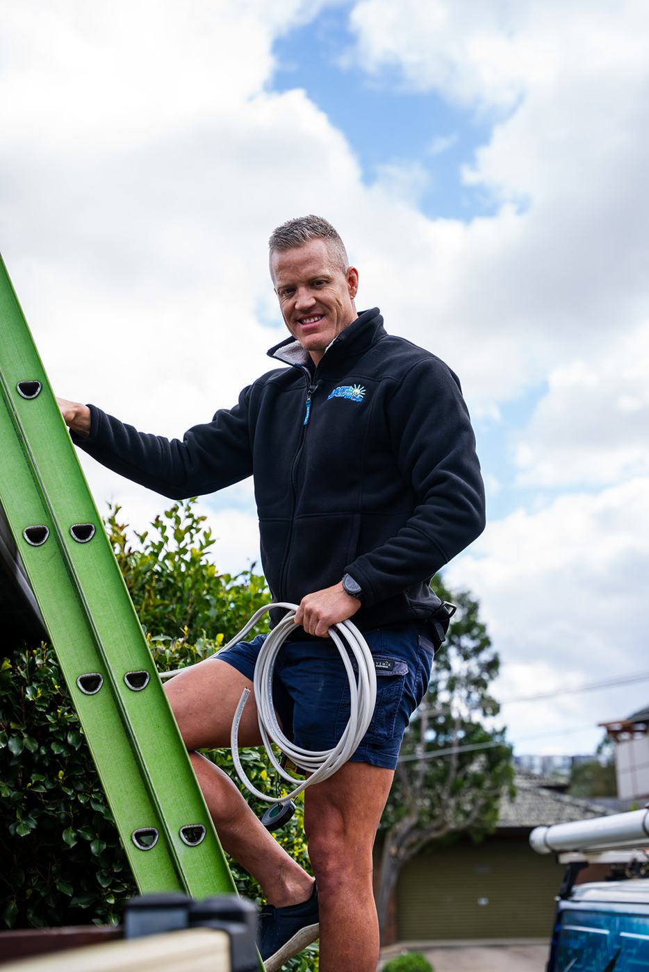 Electrician climbing a ladder outdoors